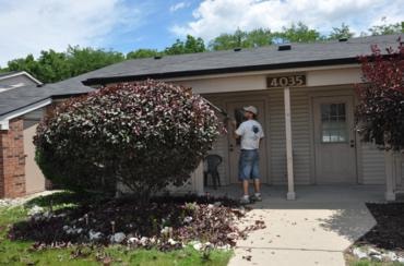 Small brick house with rounded shrub professional pruning