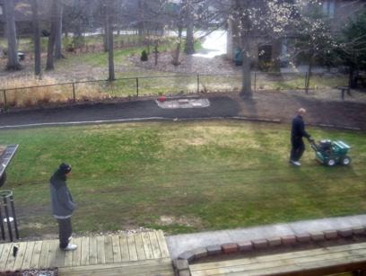 Back yard of house before slice seeding — bare and patchy lawn